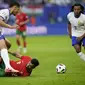 Gelandang Portugal Bruno Fernandez terjungkal saat berebut bola dengan bek Prancis William Saliba pada laga perempat final Euro 2024 (AP)