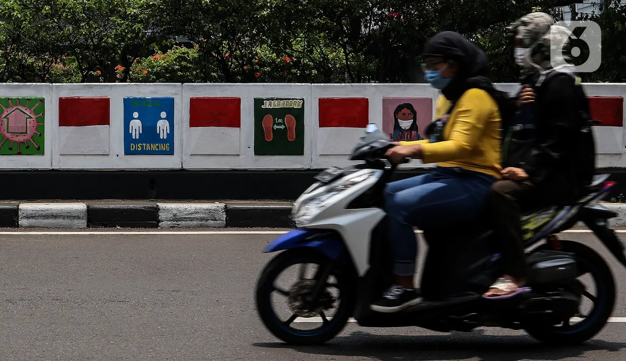 Warga melintasi mural sosialisasi bahaya COVID-19 di Jalan Sultan Iskandar Muda, Jakarta, Rabu (23/9/2020). PSBB pengetatan sepekan terakhir ini belum efektif menurunkan angka jumlah harian Covid-19 di DKI yang tercatat bertambah 1.122 kasus di ibu kota pada Selasa (22/9). (Liputan6.com/Johan Tallo)