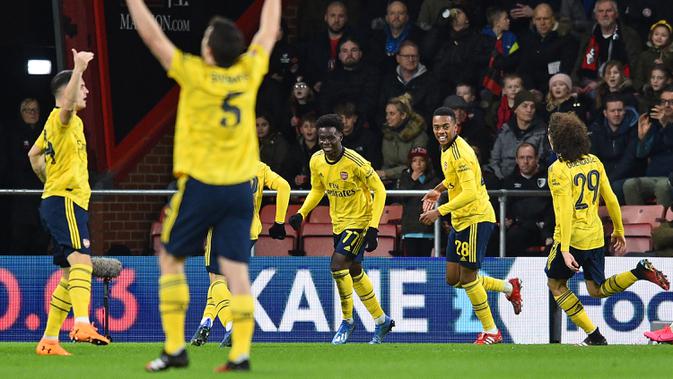 Penyerang Arsenal, Bukayo Saka (tengah) berselebrasi dengan rekan-rekannya usai mencetak gol ke gawang Bournemouth pada pertandingan putaran keempat Piala FA di Stadion Vitalitas di Bournemouth, Inggris (27/1/2020). Arsenal menang tipis 2-1 atas Bournemouth. (AFP Photo/Glyn Kirk)