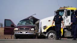 Petugas mengecek lokasi kecelakaan mematikan truk yang menabrak mobil SUV di Holtville, California (2/3/2021). Insiden itu terjadi di jalan bebas hambatan di daerah Holtville, California pada Selasa (2/3). (AP Photo/Gregory Bull)