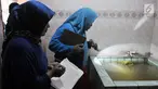 Tim Juru Pemantau Jentik (Jumantik) Kelurahan Duren Sawit melakukan pemantauan jentik nyamuk Aedes Aegypti pada bak mandi salah satu warga di kawasan Duren Sawit, Jakarta, Rabu (27/2). (Merdeka.com/Iqbal S. Nugroho)