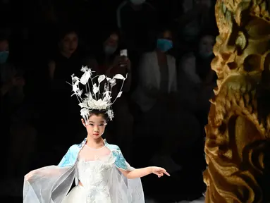 Seorang model cilik menampilkan kreasi dari koleksi Jinshangyuyi karya desainer Wang Cong selama China Fashion Week di Beijing pada Kamis (9/9/2021). Gelaran pekan mode tersebut tetap digelar di tengah pandemi corona covid-19. (Giok GAO / AFP)