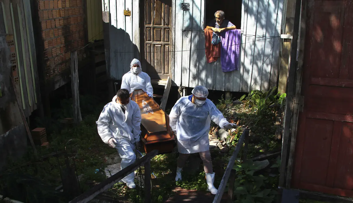 Anggota keluarga menyaksikan petugas pemakaman mengeluarkan jenazah Amelia Dias Nascimento (94) yang meninggal akibat komplikasi COVID-19 di rumahnya, di Manaus, negara bagian Amazonas (22/1/2021). Jumlah orang meninggal di rumah di tengah pandemi meningkat di Brasil. (AP Photo/Edmar Barros)