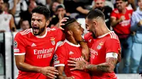 Pemain Benfica David Neres, tengah, merayakan dengan Gon&ccedil;alo Ramos, kiri, dan Henrique Ara&uacute;jo setelah mencetak gol ke gawang Juventus dalam pertandingan sepak bola grup H Liga Champions antara Juventus dan Benfica di stadion Allianz di Turin, Italia, pada Rabu, 14 September 2022. (Marco Alpozzi/LaPresse via AP)