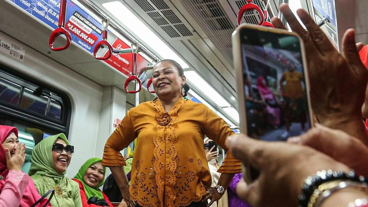 Seseorang sedang mengambil gambar peserta saat bergaya di dalam gerbong LRT. (Liputan6.com/Angga Yuniar)