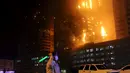 Petugas pemadam berusaha memadamkan api yang membakar gedung apartemen mewah di Ajman, Uni Emirat Arab (UEA), Senin (28/3) malam waktu setempat. Untuk sementara, dugaan terkuat mengacu pada hubungan arus pendek alias korsleting. (REUTERS/Stringer)