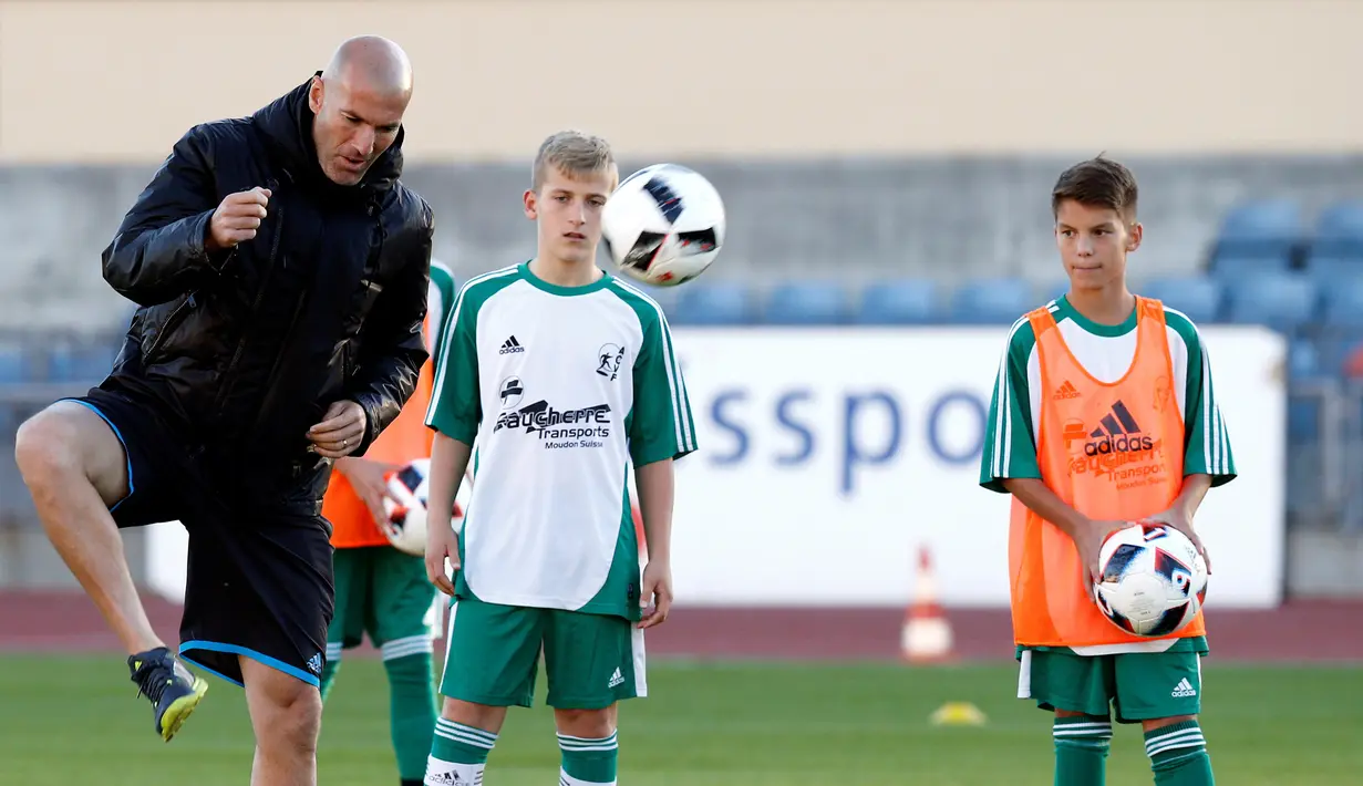 Para pemain memperhatikan teknik yang diajarkan oleh Zidane, Lausanne, Senin (3/10). Pelatih Real Madrid itu mengunjungi Swiss dalam rangka pelatihan untuk seleksi tim U14 Canton de Vaud. (REUTERS/Denis Balibouse)