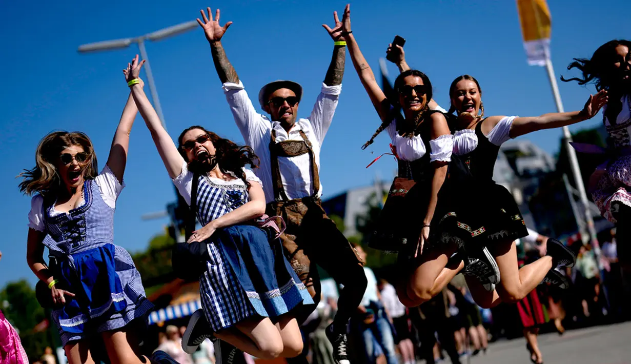 Orang-orang yang mengenakan pakaian tradisional lederhosen dan dirndl berbondong-bondong menuju tempat festival di Munich pada Sabtu pagi, memenuhi lusinan tenda tradisional untuk mendapatkan segelas bir 1 liter (2 pint) pertama mereka. (AP Photo/Matthias Schrader)
