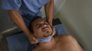 Seorang chiropractor melakukan perawatan pemulihan pasien terpapar virus Corona COVID-19 di pusat kesehatan yang dikelola pemerintah di lingkungan Coche di Caracas, Venezuela pada 25 Februari 2021. (AP Photo / Matias Delacroix)