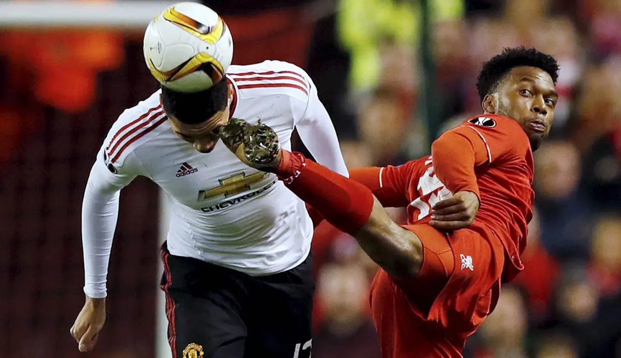 Kaki dari striker Liverpool, Daniel Sturridge, mengenai kepala bek MU, Chris Smailing. Pada laga itu wasit mengeluarkan enam kartu merah, tiga untuk Liverpool dan tiga untuk MU. (Reuters/Phil Noble) 