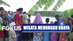Mereka yang datang berasal dari luar desa duduk di pinggir sungai untuk melihat munculnya buaya di Sungai Bengawan Solo.