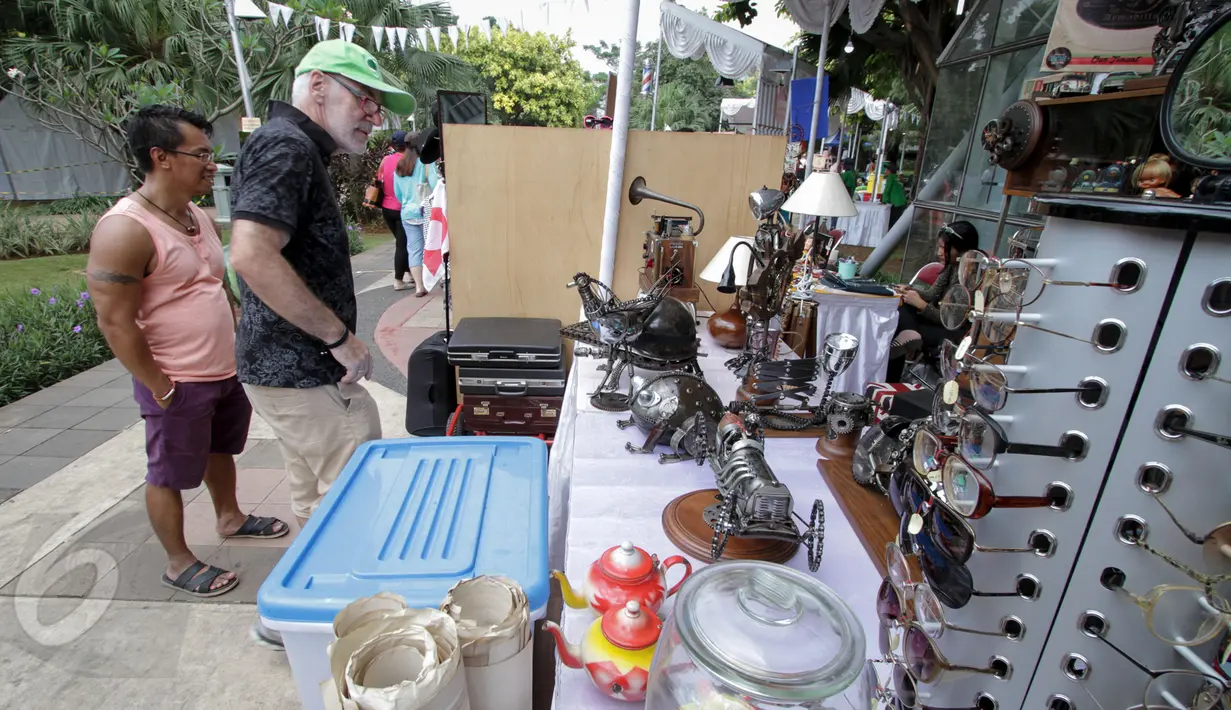 Seorang turis asing tampak melihat salah satu kios barang antik di Pasar Maci atau pasar barang-antik di Taman Menteng, Jakarta, Minggu (31/5). Acara tersebut menjual sejumlah barang antik. (Liputan6.com/Faizal Fanani)