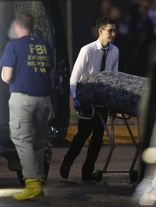 Petugas membawa jenazah korban penembakan brutal saat olah TKP klub gay Pulse di Kota Orlando, Florida, AS, Minggu (12/6). Pelaku yang membawa senapan mesin jenis AR15 dan pistol sempat menyandera beberapa orang (Joe Raedle/GETTY IMAGES NORTH AMERICA/AFP)