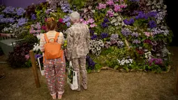 Orang-orang melihat kios bunga Dibleys selama RHS Chelsea Flower Show 2021 di London pada Senin (20/9/2021). Pertunjukan bunga ChelseA sempat ditunda dari tanggal musim semi biasanya karena pembatasan penguncian di tengah penyebaran pandemi COVID-19. (AP Photo/Matt Dunham)