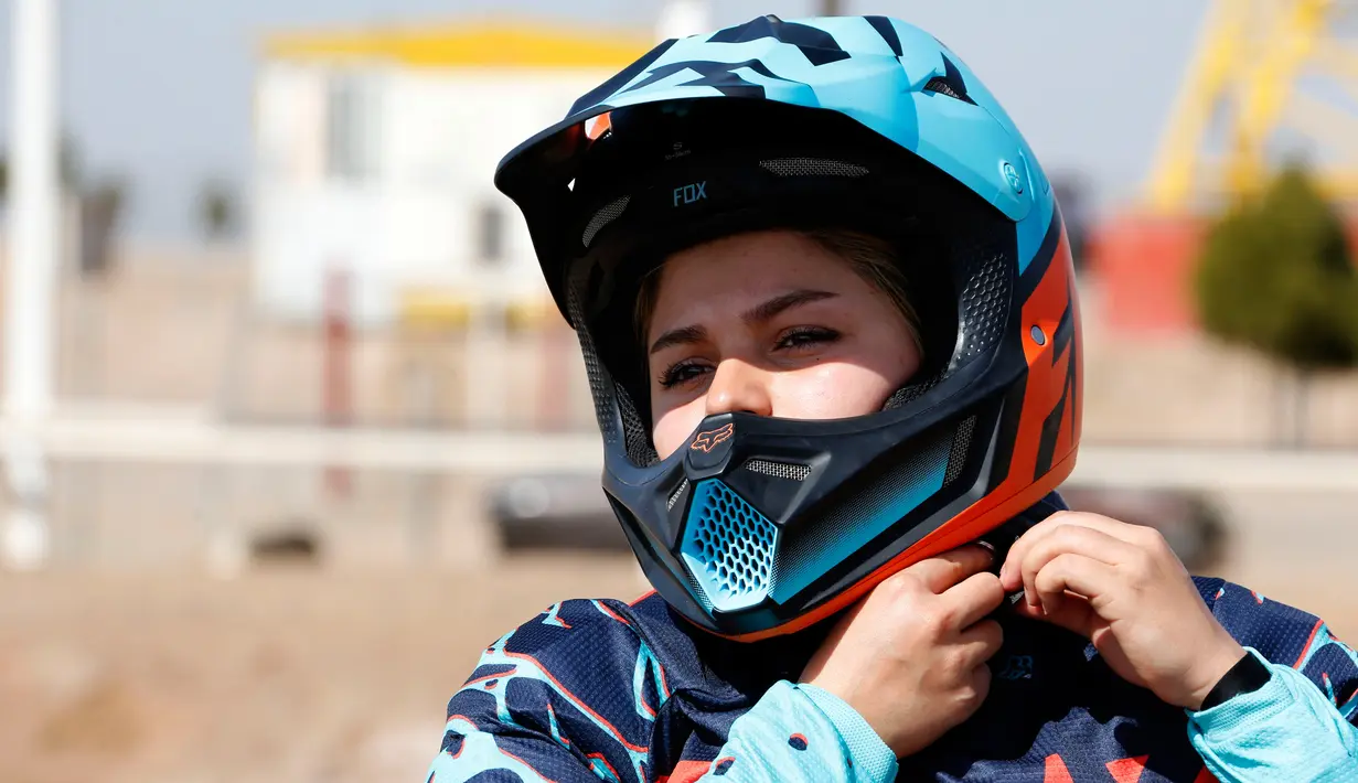 Behnaz Shafiei mengenakan helm jelang latihan di Parand, Teheran (27/2). Shafiei menjadi simbol kebebasan perempuan di Iran yang merupakan salah satu negara yang melarang kaum hawa berkendara di jalan umum. (AFP PHOTO/Atta Kenare)