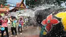 Warga dan seekor gajah saling menyiramkan air dalam perayaan festival air Songkran di provinsi Ayutthaya, utara Bangkok, Thailand, (11/4). Selama perayaan Songkran, warga melakukan perang air di jalanan dan di tempat umum. (AP Photo/Sakchai Lalit)