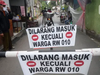 Sejumlah pemuda menjaga portal karantina wilayah menuju RW 10 di kawasan Tanah Kusir, Kelurahan Kebayoran Lama Selatan, Jakarta, Rabu (8/4/2020). Warga menerapkan akses satu pintu masuk pemukiman yang terdiri dari 12 RT tersebut untuk mencegah penyebaran corona COVID-19. (merdeka.com/Dwi Narwoko)