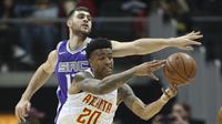 Forward Atlanta Hawks, John Collins (depan) dijaga penggawa Sacramento Kings, Georgios Papagiannis, pada laga NBA 2017-2018 di Philips Arena, Rabu (15/11/2017) atau Kamis (16/11/2017) WIB. (AP Photo/John Bazemore)