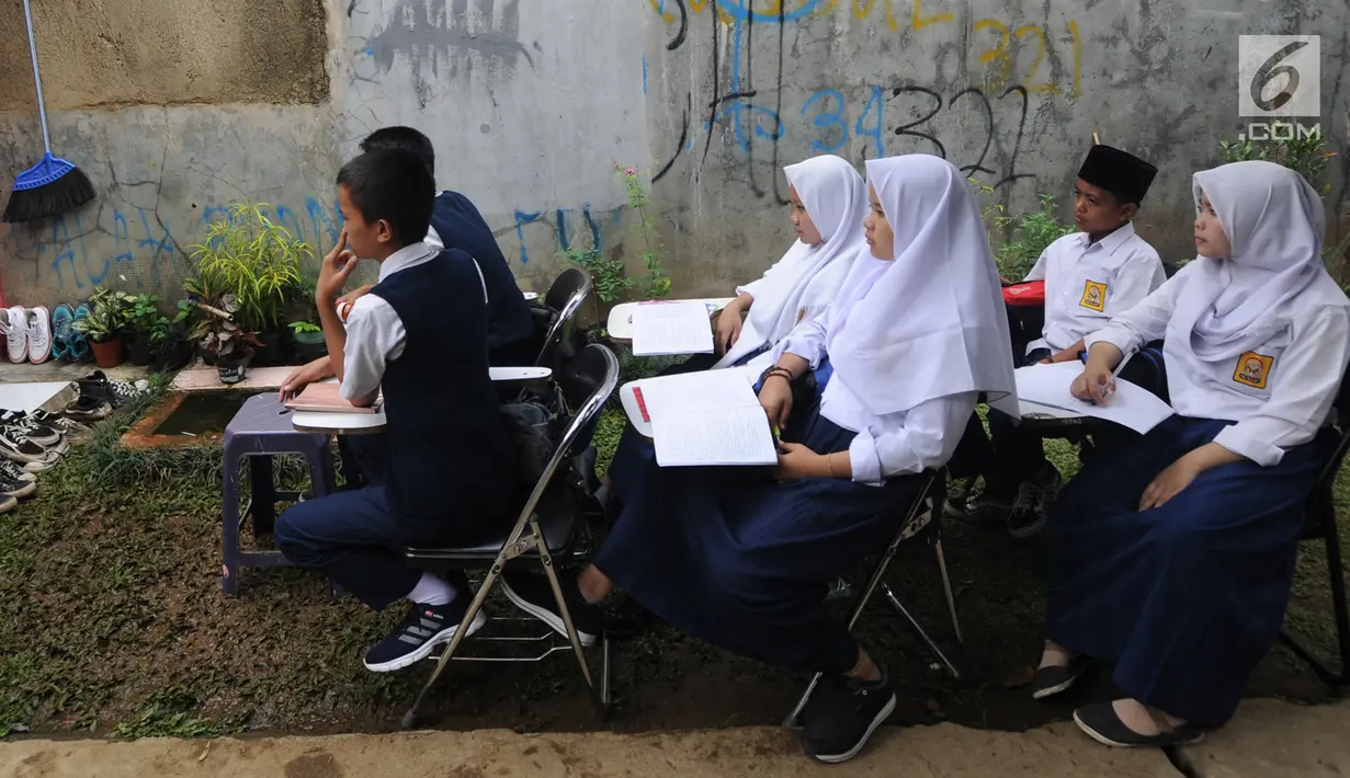 Siswa kelas 8 SMP 1 Cijeruk Terbuka belajar di halaman rumah warga di Kampung Cijeruk RT 002/005, Desa Palasari, Kabupaten Bogor, Jawa Barat, Senin (2/9/2019). Para siswa belajar di halaman depan dan belakang rumah warga setelah sebelumnya menumpang di gedung madrasah. (merdeka.com/Arie Basuki)