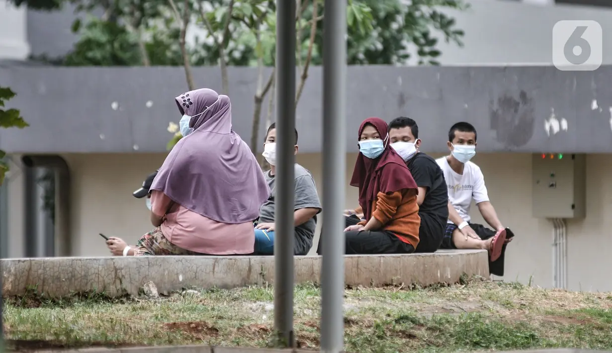 Pasien bersama anaknya yang terpapar Covid-19 saat berolahraga di sekitar taman Rumah Sakit Darurat (RSD) Wisma Atlet, Kemayoran, Jakarta, Minggu (6/12/2020). Setiap pagi dan sore hari pihak RSD Wisma Atlet memperbolehkan pasien Covid-19 keluar kamar untuk berolahraga. (merdeka.com/Iqbal Nugroho)