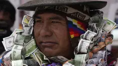 Seseorang berpakaian seperti Ekeko, Dewa Kemakmuran, diselimuti uang palsu pada hari pembukaan Pameran Alasita tahunan, di mana Ekeko adalah tokoh utamanya di El Alto, Bolivia, Selasa (24/1/2023). Orang-orang membeli replika kecil dari hal-hal yang ingin mereka peroleh sepanjang tahun, seperti rumah, mobil, dan kekayaan. Kata Aymara "Alasita" berarti "belikan aku". (AP Photo/Juan Karita)