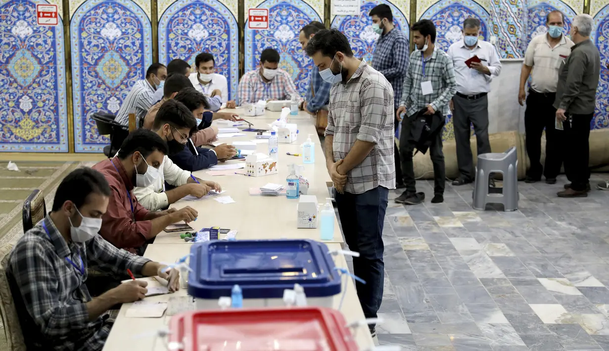 Warga berbaris untuk memberikan suara dalam pemilihan presiden di sebuah tempat pemungutan suara di Teheran, Iran, Jumat (18/6/2021). Warga Iran mulai memberikan suaranya dalam pemilihan presiden. (AP Photo/Ebrahim Noroozi)