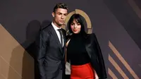 Bintang Real Madrid, Cristiano Ronaldo ditemani kekasihnya, Georgina Rodriguez menghadiri acara Quina Awards di Lisbon, Portugal, Senin (19/3). Ronaldo tampil gagah dengan setelan jas hitam saat berpose di depan kamera. (AP/Armando Franca)