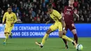 Penyerang PSG, Kylian Mbappe, berebut bola dengan bek Metz, Chris Philipps, pada laga Ligue 1 Prancis di Stadion Saint-Symphorien, Moselle, Jumat (8/9/2017). Metz kalah 1-5 dari PSG. (AFP/Patrick Hertzog)