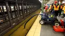 Para pekerja menyedot air dari stasiun kereta bawah tanah Lincoln Center yang banjir di New York, Amerika Serikat, Senin (13/1/2020). Genangan air menghambat layanan kereta bawah tanah pada jam sibuk. (AP Photo/Richard Drew)