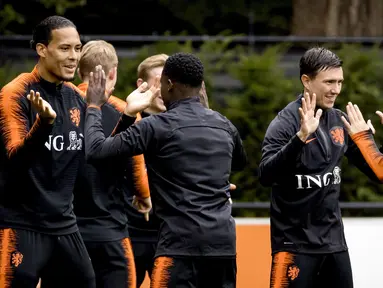 Pemain Belanda Virgil van Dijk, Quincy Promes, Steven Berghuis dan Stefan de Vrij bercanda saat mengikuti sesi latihan tim di Zeist (9/10/2019). Timnas Belanda akan bertanding melawan Irlandia Utara pada grup C kualifikasi Euro 2020 di Stadion Feijenoord. (Koen van Weel/ANP/AFP)