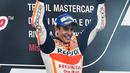 Pembalap Repsol Honda, Marc Marquez memegang trofi juara balapan MotoGP San Marino 2017 di atas podium, Minggu (10/9). Kemenangan Marquez cukup dramatis dengan menyalip pembalap Octo Pramac Ducati Danilo Petrucci di putaran terakhir. (ANDREAS SOLARO/AFP)