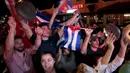 Warga Kuba bersorak saat turun ke jalan merayakan wafatnya Fidel Castro di Miami, AS (26/11). Mereka merupakan warga Kuba yang melarikan diri ke negara lain saat Castro berkuasa. (REUTERS/Javier Galeano)
