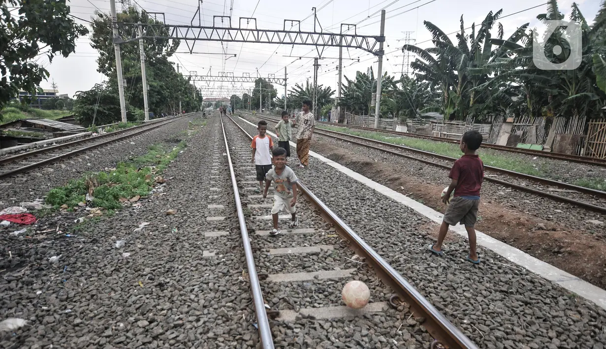 Anak-anak saat bermain di dekat rel kereta api di kawasan Bahari Ujung, Tanjung Priok, Jakarta Utara, Selasa (24/5/2022). Minimnya fasilitas dan ruang terbuka hijau di kawasan tersebut menyebabkan anak-anak setempat memilih bermain di sekitar perlintasan kereta api yang dapat membahayakan keselamatan mereka. (merdeka.com/Iqbal S Nugroho)