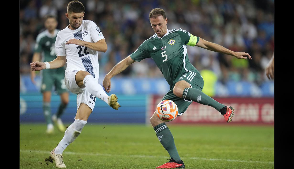 Bek Timnas Irlandia Utara, Jonny Evans (kanan), berusaha mengecoh pemain Slovenia, Adam Gnezda Čerin, dalam dalam pertandingan kualifikasi Euro 2024 di Stozice stadium, Ljubljana, Slovenia, Jumat (8/9/2023). Sempat tertinggal 1-3, Jhonny Evans ikut membantu serangan Irlandia Utara. (AP Photo/Darko Bandic)