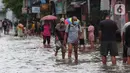 <p>Warga berjalan melewati banjir di Perumahan Ciledug Indah 1 dan 2, Kota Tangerang, Banten, Sabtu (16/7/2022). Banjir yang merendam perumahan Ciledug Indah tersebut akibat meluapnya Kali Angke. (Liputan6.com/Angga Yuniar)</p>