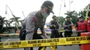 Petugas memasang garis polisi di lokasi bom bunuh diri di Mapolresta Solo, Jawa Tengah, Selasa (5/7). Garis polisi tersebut dipasang mulai dari sisi barat jalan Adi Sucipto menuju sisi timur Jalan KS Tubun. (Liputan6.com/Boy Harjanto)