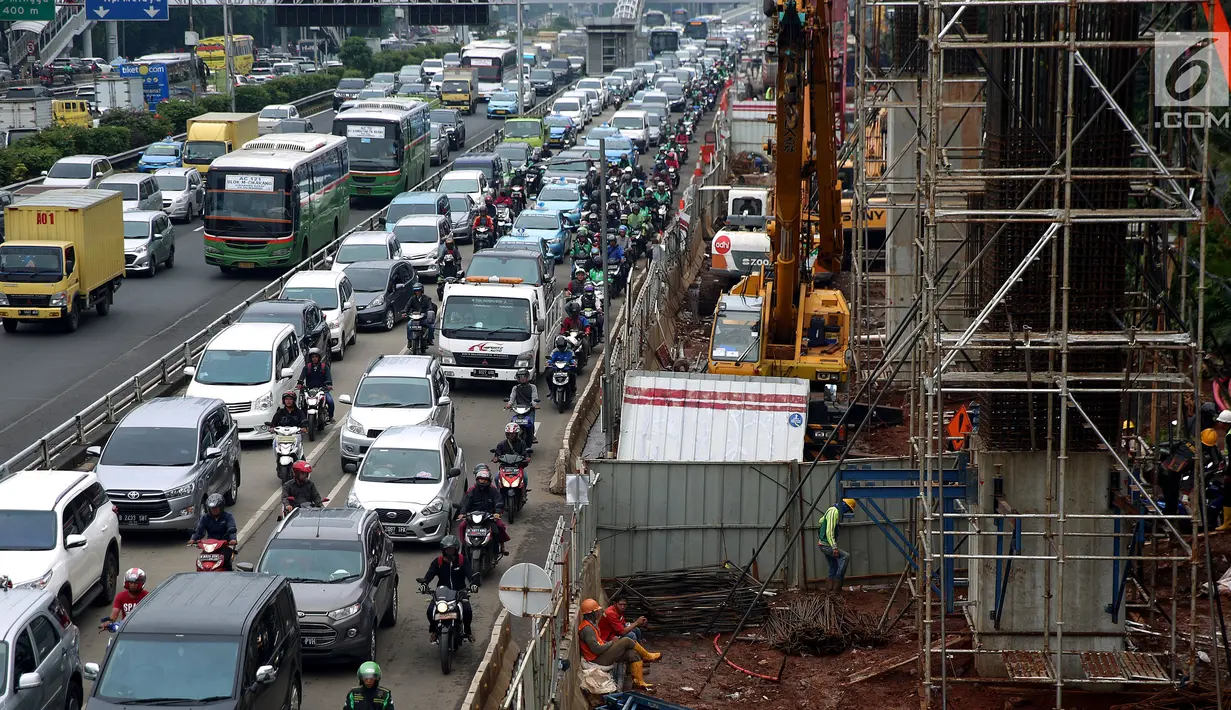 Kendaraan melintas di bawah proyek pembangunan kereta ringan rute Cawang-Dukuh Atas di kawasan Gatot Subroto, Jakarta, Kamis (18/1). Progres pembangunan LRT Jabodebek saat ini mencapai kurang lebih 30 persen. (Liputan6.com/JohanTallo)