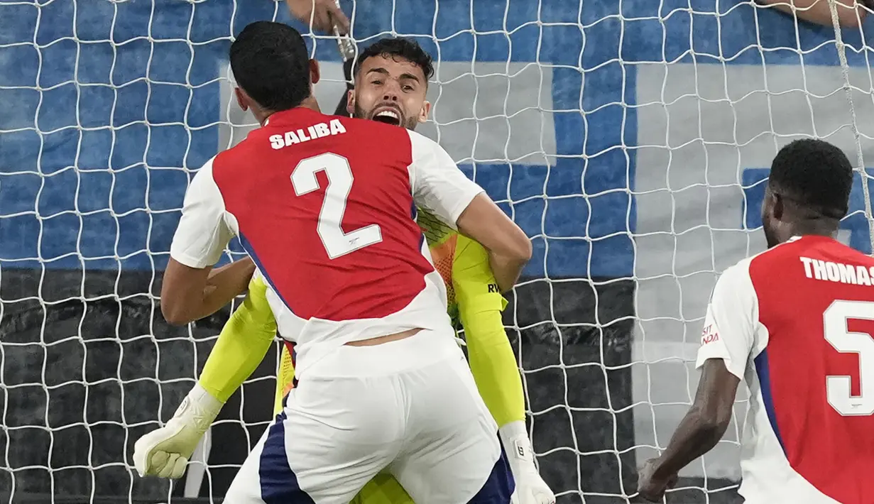 Kiper Arsenal, David Raya melakukan selebrasi bersama William Saliba setelah melakukan penyelamatan gemilang pada laga Liga Europa 2023/2024 melawan Atalanta di Atleti Azzurri d'Italia stadium, Bergamo, Italia, Jumat (20/09/2024) WIB. (AP Photo/Antonio Calanni)