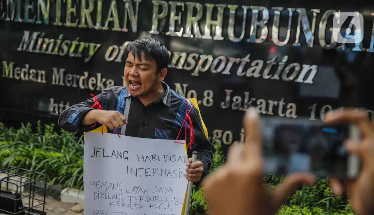 Fazlur Rahman, penyandang disabilitas (tunanetra) korban kecelakaan Commuter Line berunjuk rasa seorang diri di depan kantor Kemenhub, Jakarta, Rabu (27/11/2019). PT KCI dinilai abai terhadap fasilitas dan penanganan penyandang disabilitas di tempat pelayanan publik. (Liputan6.com/Faizal Fanani)