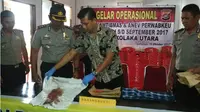 Kapolres Kolaka Utara, AKBP Bambang Satriawan, saat memperlihatkan barang bukti berupa baju korban yang berdarah dan sebilah pisau pengiris buah, Jumat (20/10/2017). (Liputan6.com/Ahmad Akbar Fua)