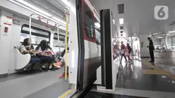 Penumpang menaiki Kereta api ringan atau Light Rail Transit (LRT) di Stasiun Velodrome, Rawamangun, Jakarta, Rabu (27/11/2019). Moda transportasi massal LRT Jakarta akan beroperasi komersial per 1 Desember 2019 dengan tarif Rp5.000 untuk sekali perjalanan. (merdeka.com/Iqbal Nugroho)
