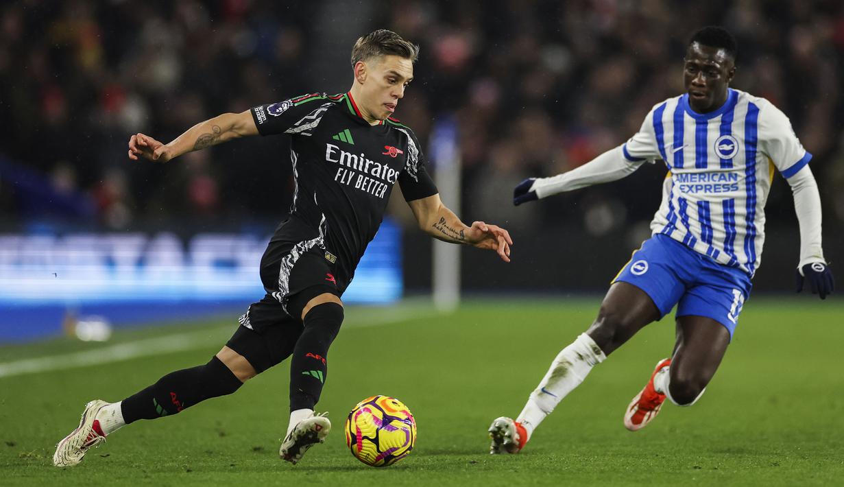 Pemain Arsenal, Leandro Trossard (kiri) berusaha melewati pemain Brighton, Yankuba Minteh dalam laga lanjutan Liga Inggris 2024/2025 di American Express Community Stadium, Brighton, Inggris, Sabtu (04/01/2025). (AP Photo/Ian Walton)