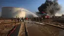 Petugas pemadam kebakaran berupaya memadamkan kebakaran di kilang minyak Zawiya setelah serangan pesawat nirawak di Zawiya, Libya, Selasa, 11 Agustus 2026. (AP/Yousef Murad)