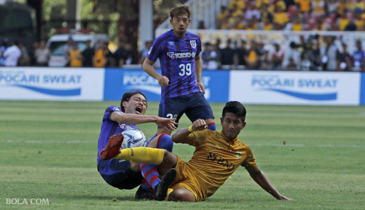 Tekel keras Putu Gede asal  Bhayangkara FC terhadap Keigo Higashi gelandang FC Tokyo dalam laga persahabatan di Stadion Utama Gelora Bung Karno, Senayan Jakarta pada Sabtu (27/1/2018).  (Bola.com/Peksi Cahyo)