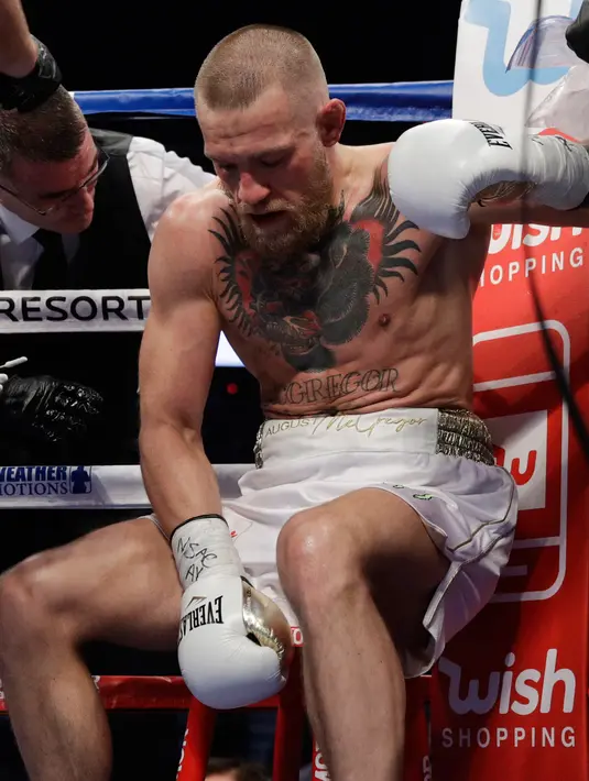 Conor McGregor duduk di sudut saat istrahat pertandingan tinju super kelas welter di Las Vegas (26/8). (AP Photo/Isaac Brekken)