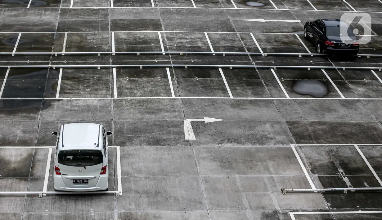 Dua mobil terparkir di lahan parkir sebuah gedung, Jakarta, Kamis (1/5/2020). Indonesia Parking Association (IPA) menyatakan terjadi penurunan bisnis parkir sebesar 75-90 persen seiring penerapan PSBB untuk mencegah penyebaran COVID-19 di Jabodetabek. (Liputan6.com/Faizal Fanani)