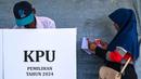 Pemilihan Kepala Daerah (Pilkada) menjadi pesta demokrasi kedua yang berlangsung di Indonesia pada tahun 2024, setelah sebelumnya, pada Februari lalu dilaksanakan Pemilihan Umum Legislatif dan Pemilihan Presiden/Wakil Presiden. Tampak dalam foto, seorang pemilih memeriksa surat suaranya sebelum memberikan suaranya dalam pemilihan kepala daerah di Darul Imarah, pinggiran Banda Aceh, pada 27 November 2024. (CHAIDEER MAHYUDDIN/AFP)