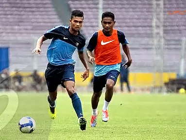 Syahrizal (kiri) berusaha mempertahankan bola dari kejaran Rizki Ramdani Lestaluhu dalam sesi latihan akhir jelang Sea Games 2013 Myanmar (Liputan6.com/Helmi Fithriansyah)