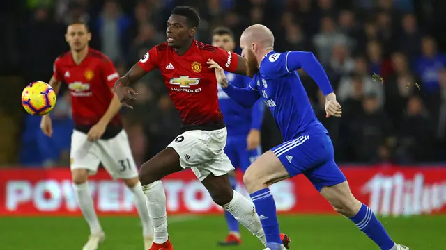Gelandang Manchester United, Paul Pogba, berusaha melewati gelandang Cardiff, Aron Gunnarsson, pada laga Premier League di Stadion Cardiff City, Wales, Sabtu (22/12). Cardiff kalah 1-5 dari MU. (AFP/Geoff Caddick)