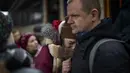 Seorang perempuan menangis saat mengucapkan selamat tinggal kepada suaminya sebelum naik kereta menuju Lviv di stasiun Kiev, 3 Maret 2022. Pria Ukraina harus tinggal untuk berperang sementara wanita dan anak-anak pergi negara untuk mencari perlindungan di negara tetangga (AP Photo/Emilio Morenatti)